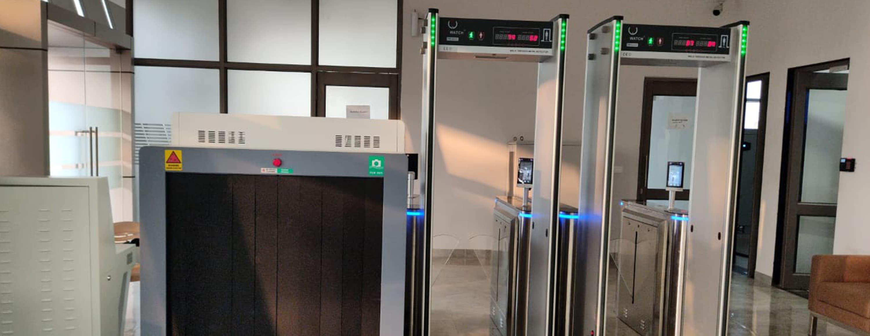 Walk-through metal detectors and an X-ray baggage scanner at a security screening checkpoint