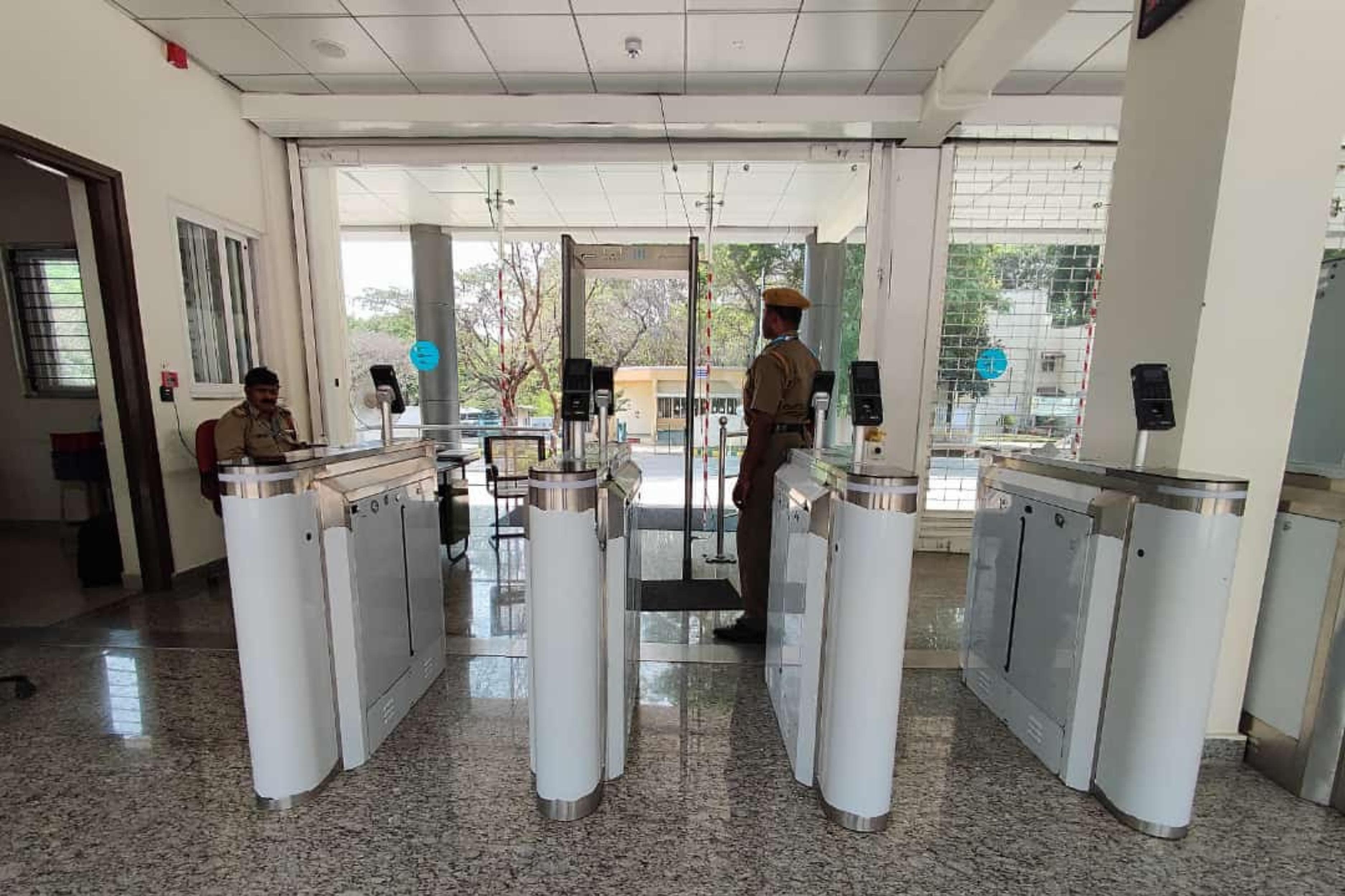 Swing barrier lanes with card and fingerprint readers in a building lobby